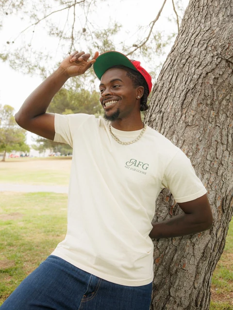 DK in the cream tee, hand to his cap