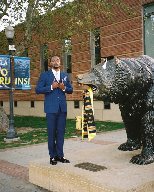 DK in a blue suit beside the UCLA bear