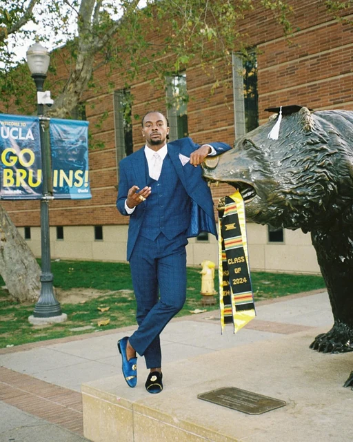 DK in a blue suit, jacket over his shoulder
