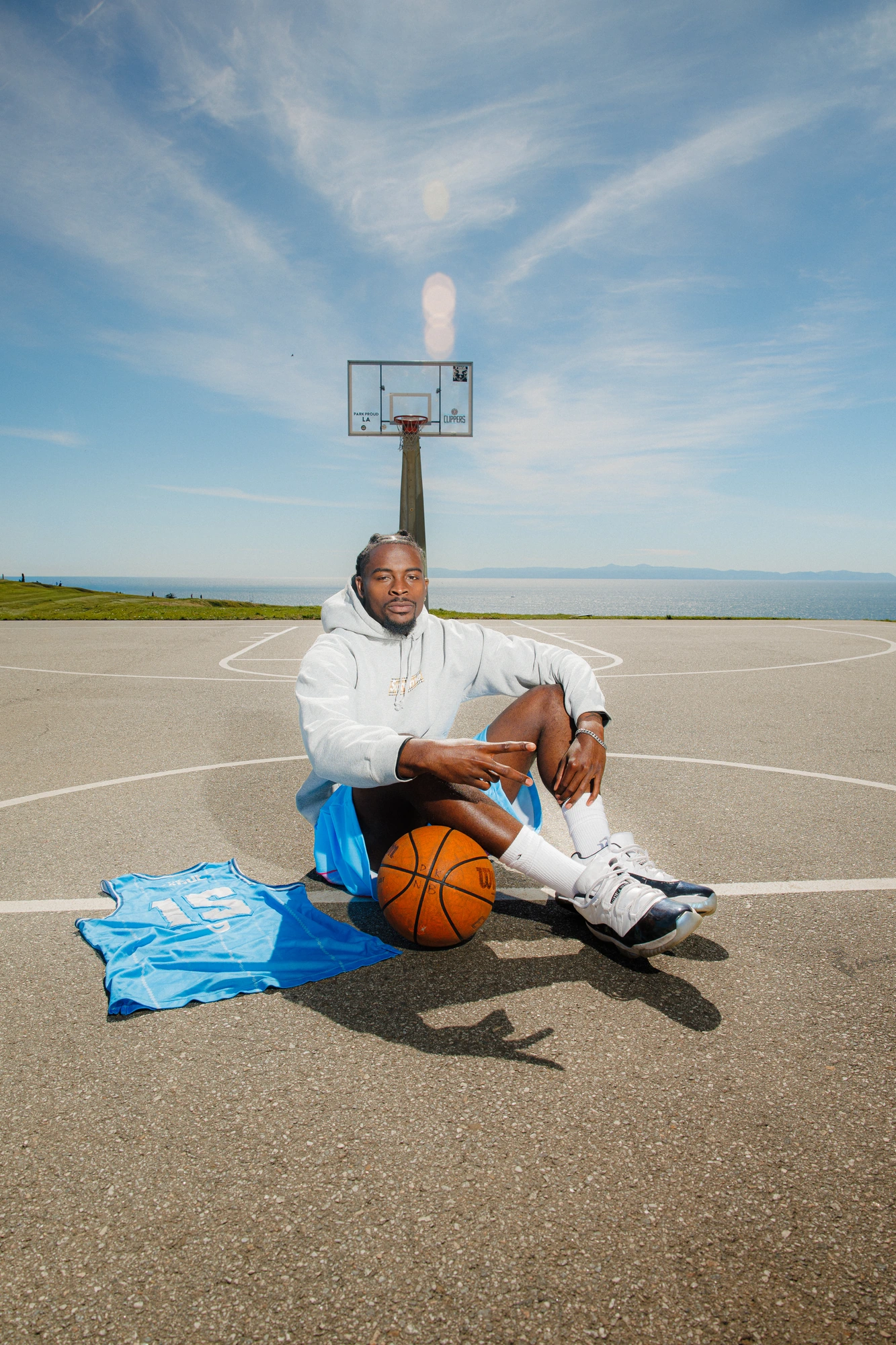 DK sitting on the court beside the ball
