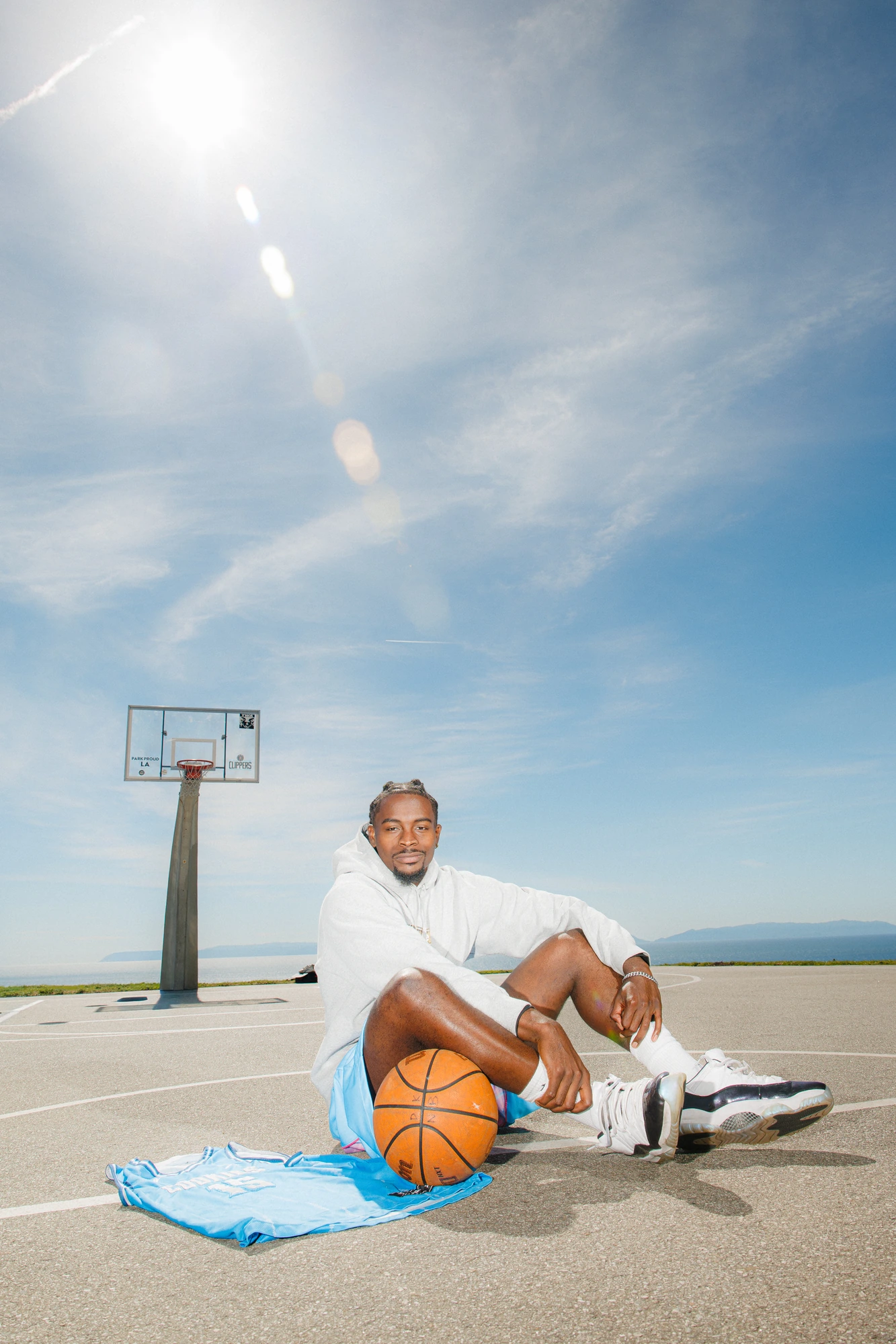 DK sitting under the hoop, sun flaring