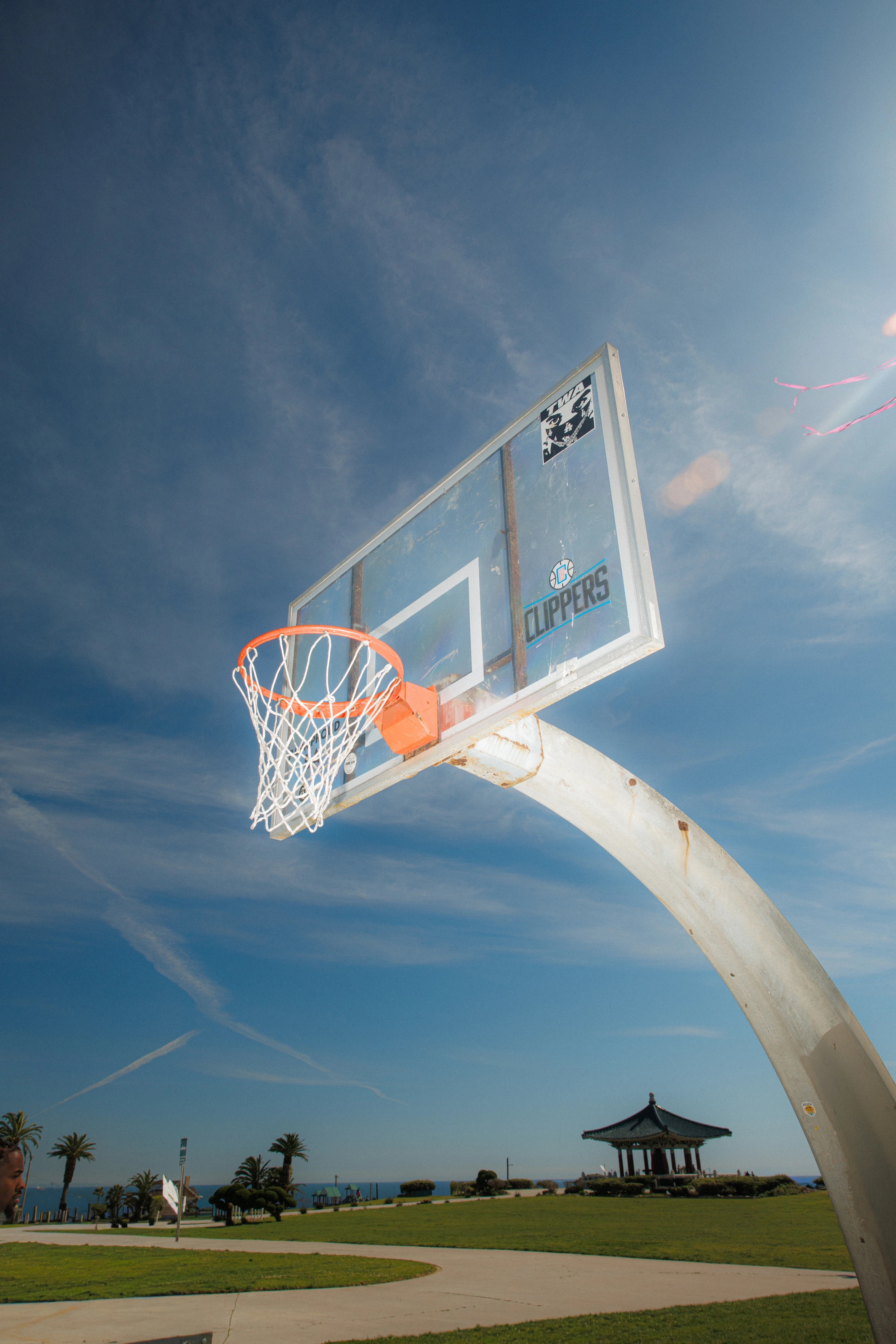 The ball dropping through the net against open sky
