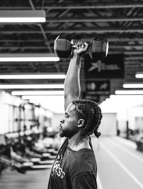 DK pressing a dumbbell overhead