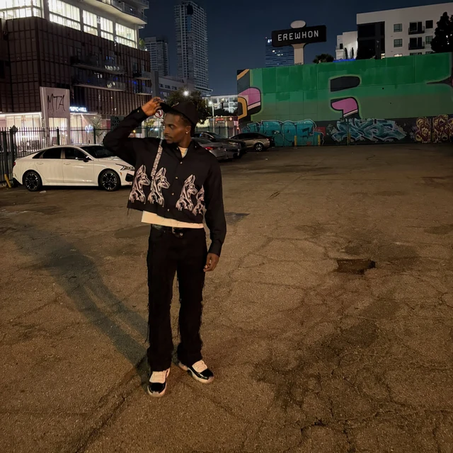 DK on La Brea at night, hand to his hat