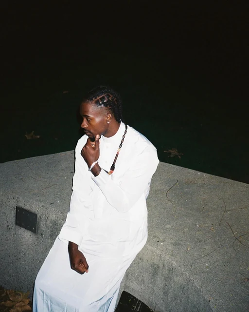 DK in a white robe, turned away, at night